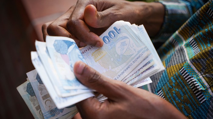 A man counts 100 Turkish lira banknotes