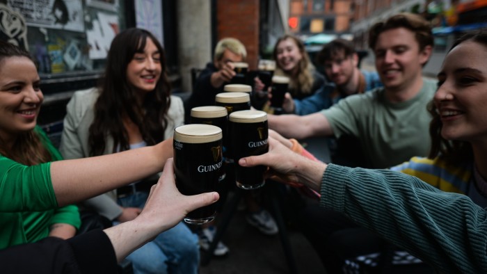 People enjoy drinking Guinness outside a pub