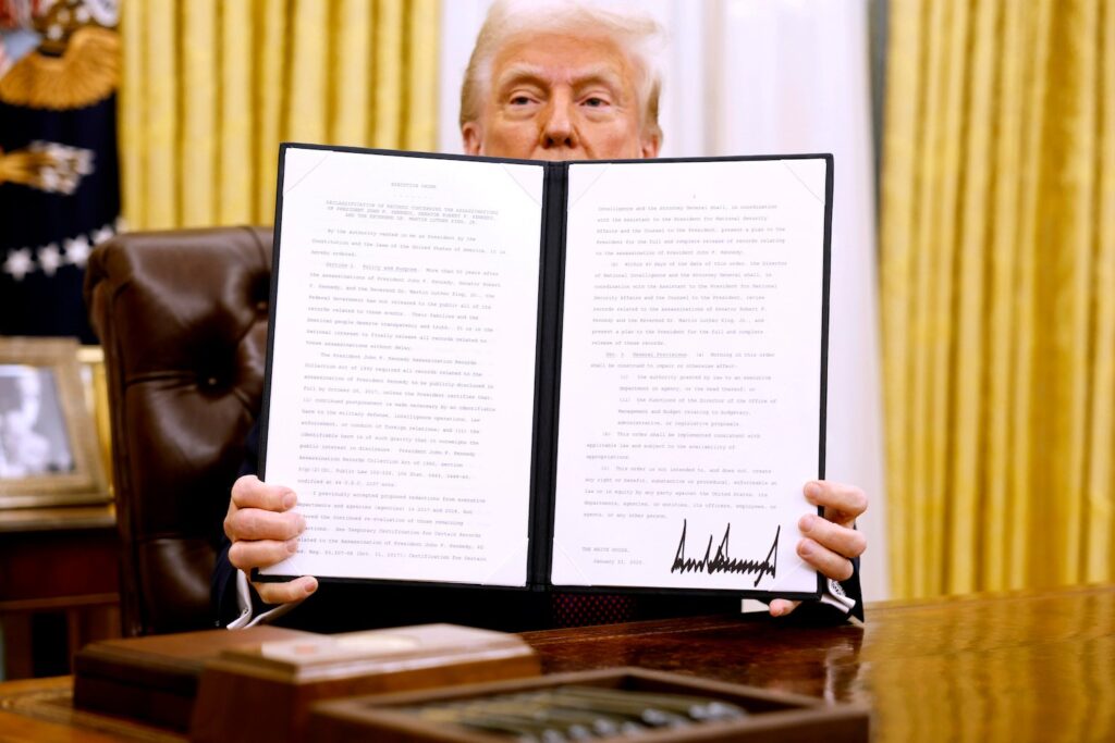 Donald Trump holds up an executive order