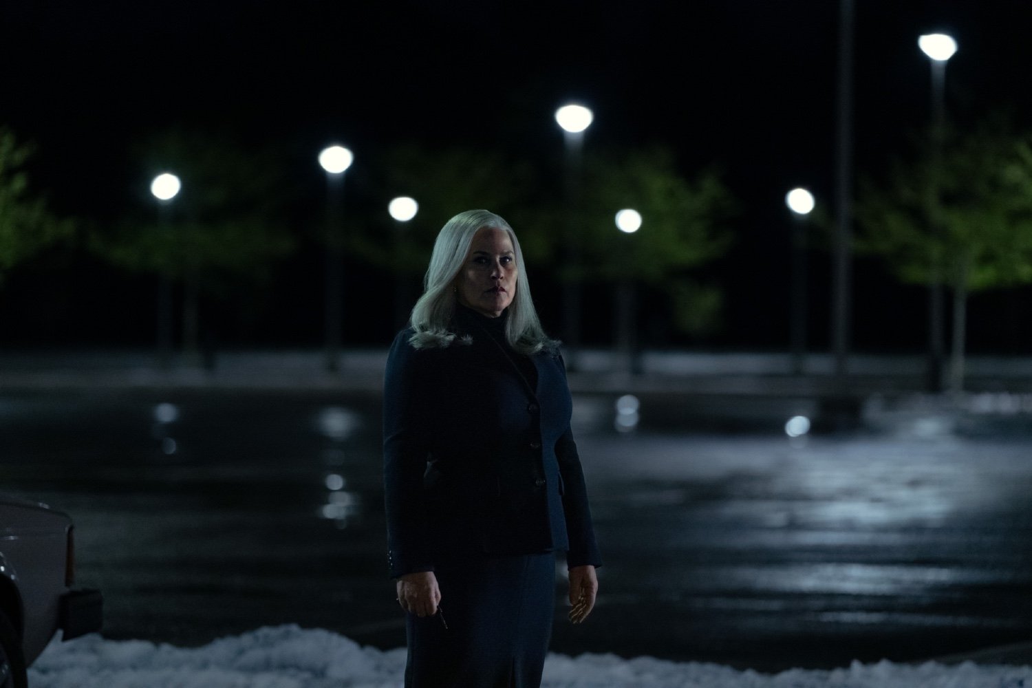 Mrs. Selvig/Ms. Cobel (Patricia Arquette) contemplates her next move in a frosty Lumon parking lot.