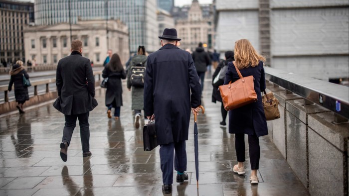 People walk across London Bridge on a wet morning