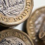 British one pound coins stand stacked in this arranged photograph