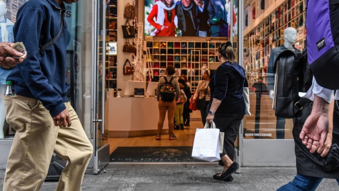 Shoppers walk past and enter a store in the Times Square neighbourhood of New York City.