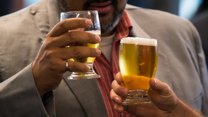 Guests hold glasses of beer during a reception following the official opening event of the Molson Coors Canada Fraser Valley Brewery in Chilliwack