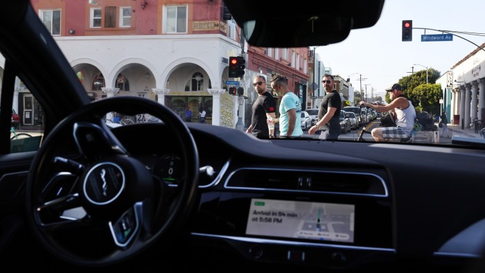 A Waymo self-driving Jaguar taxi stopped at a red light near Venice Beach in Los Angeles