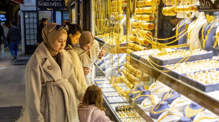 Women browse gold jewellery displayed in a store window at the Grand Bazaar in Istanbul.