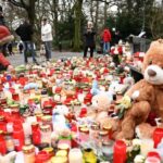 People pay their respect and lay candles at a makeshift memorial of candles flowers and soft toys for the victims of a knife attack, on January 24, 2025 in Aschaffenburg,