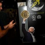 A sign featuring US President Donald Trump on a Moonshot booth during the Bitcoin 2024 conference in Nashville, Tennessee