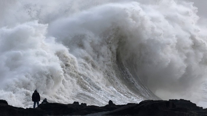 A person views large waves as Storm Eowyn arrives