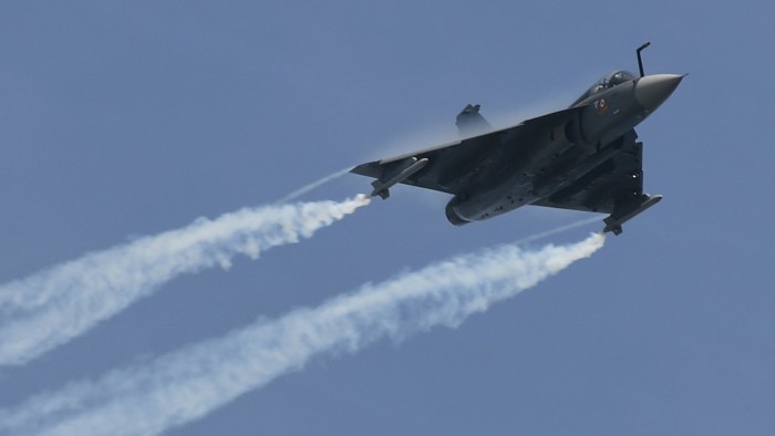 An Indian-made Tejas fighter jet leaves contrails as it flies through a clear sky