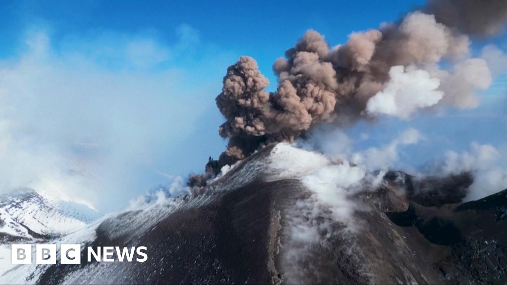 Lava and smoke emerge from a snowy Mount Etna