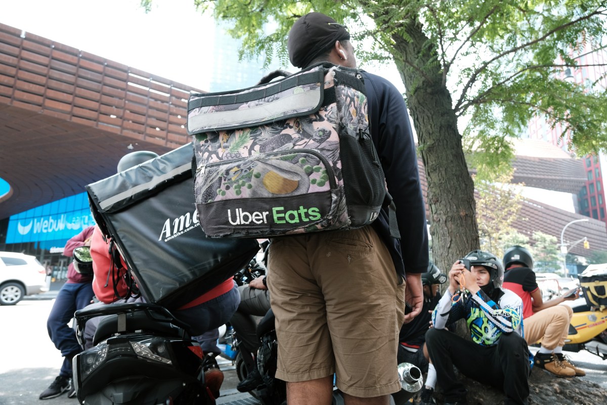 App-based delivery workers wait outside of a restaurant that uses app deliveries