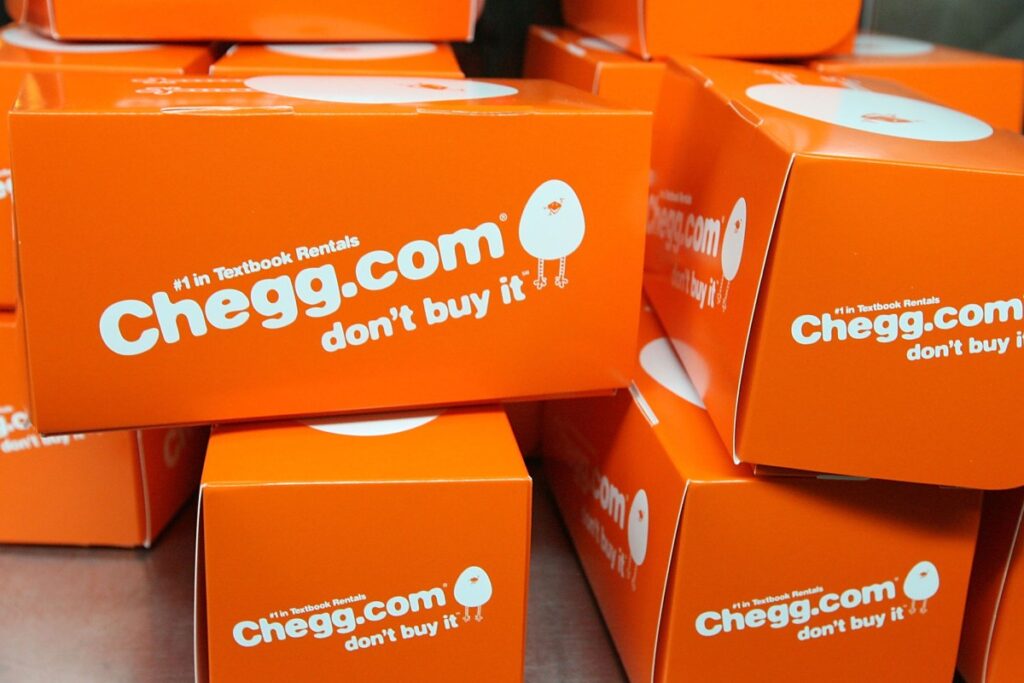 A collection of orange boxes with Chegg branding on a table.