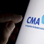 A finger points towards a smartphone screen displaying the CMA logo