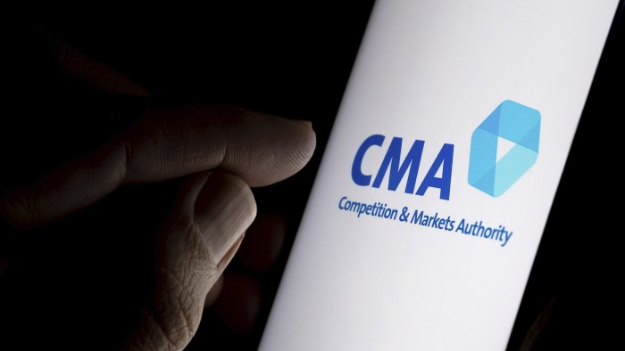 A finger points towards a smartphone screen displaying the CMA logo