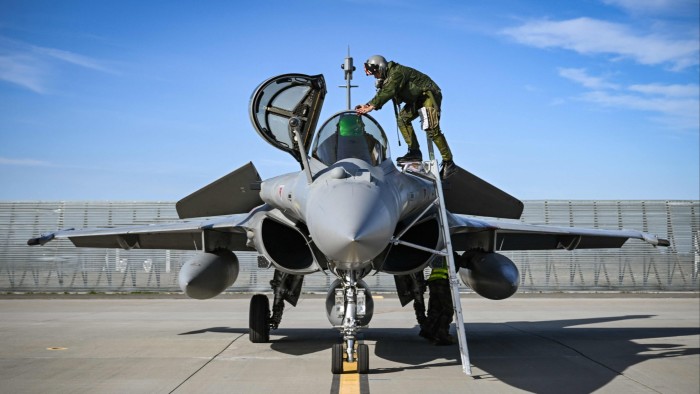 A French army pilot climbs into the cockpit of a Dassault Rafale fighter jet