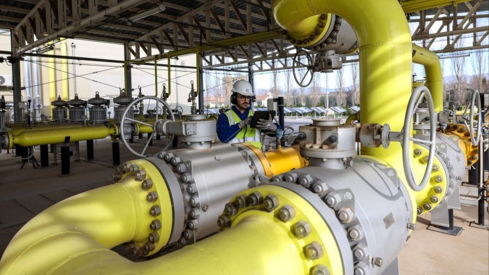 Worker inspects a gas pipe at the Pantano reduction station in Rome, Italy