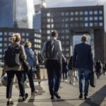 Office workers walk across London Bridge in the early evening