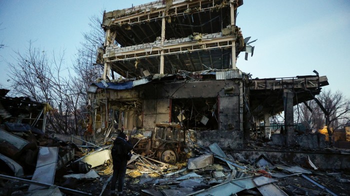 A person stands amid debris, examining the wreckage of a heavily damaged building in Kyiv following a Russian missile strike on February 12 2025