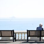 A retired couple look out to sea at Plymouth, UK