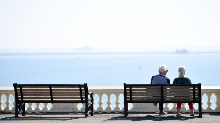 A retired couple look out to sea at Plymouth, UK