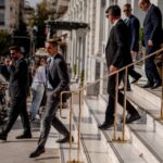 Men in suits walk down stairs