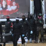 Palestinian militants carry one of the coffins as they hand over the bodies of four Israeli hostages to the Red Cross in Khan Yunis in the southern Gaza