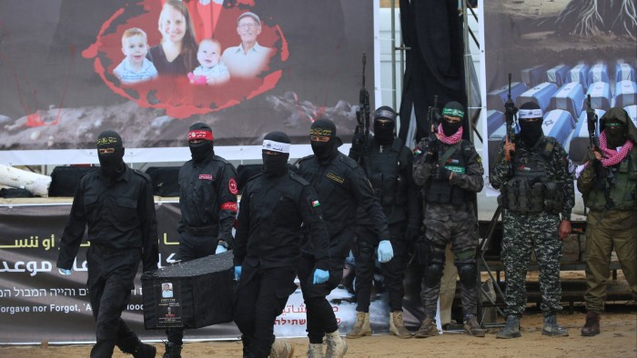 Palestinian militants carry one of the coffins as they hand over the bodies of four Israeli hostages to the Red Cross in Khan Yunis in the southern Gaza