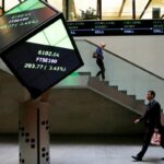 People walk through the lobby of the London Stock Exchange in London