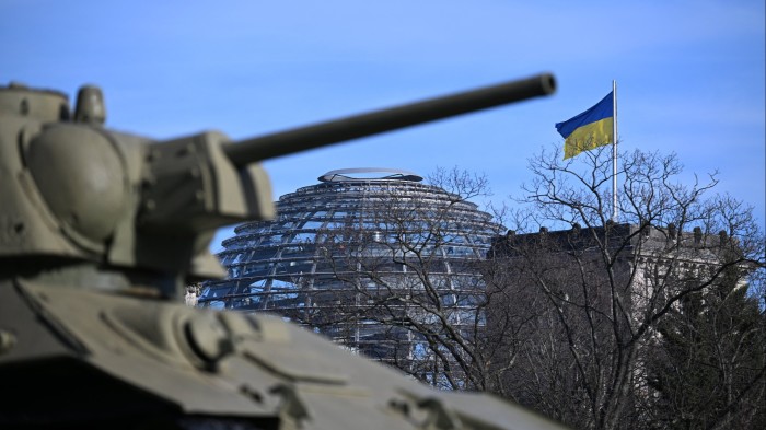 Ukrainian flag on the Reichstag building and in front an old Russian T-34 tank that is part of the Soviet War Memorial in Berlin, Germany