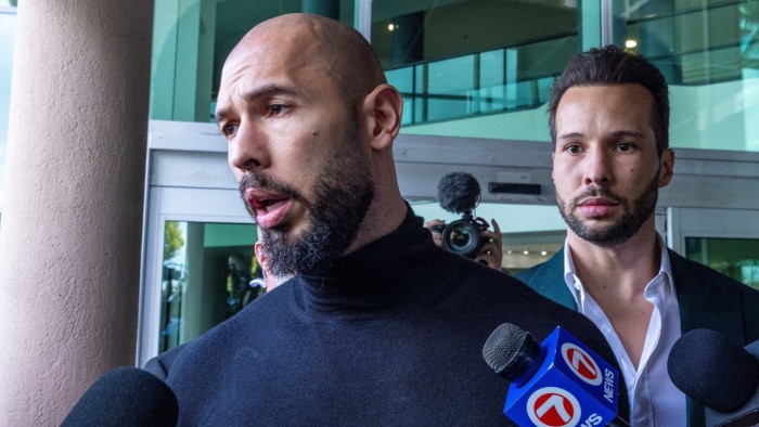 Andrew Tate (centre) speaks to the media after he and his brother Tristan (right) arrive at Fort Lauderdale airport in Florida, US