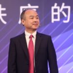 SoftBank CEO Masayoshi Son standing in front of a purple background.