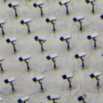 a pattern of CCTV surveillance cameras on a wall, moshed with a blue and yellow jitter effect, all pointing in different directions.