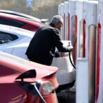 A person recharges a Tesla electric vehicle at a Tesla Supercharger station on September 23, 2024 in Pasadena, California.