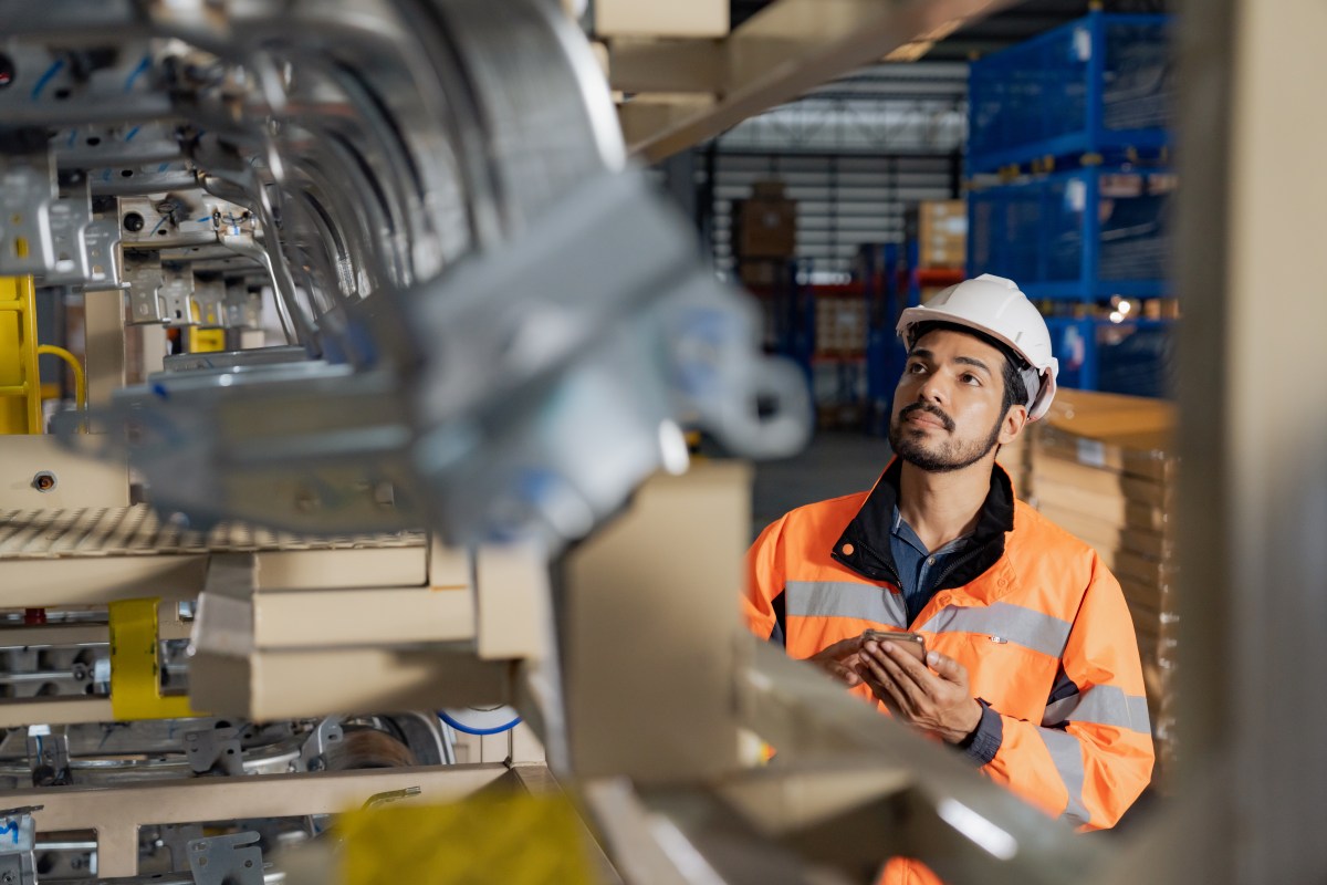 Young man industrial engineer wearing a white helmet while check the welding on the production line in the factory.