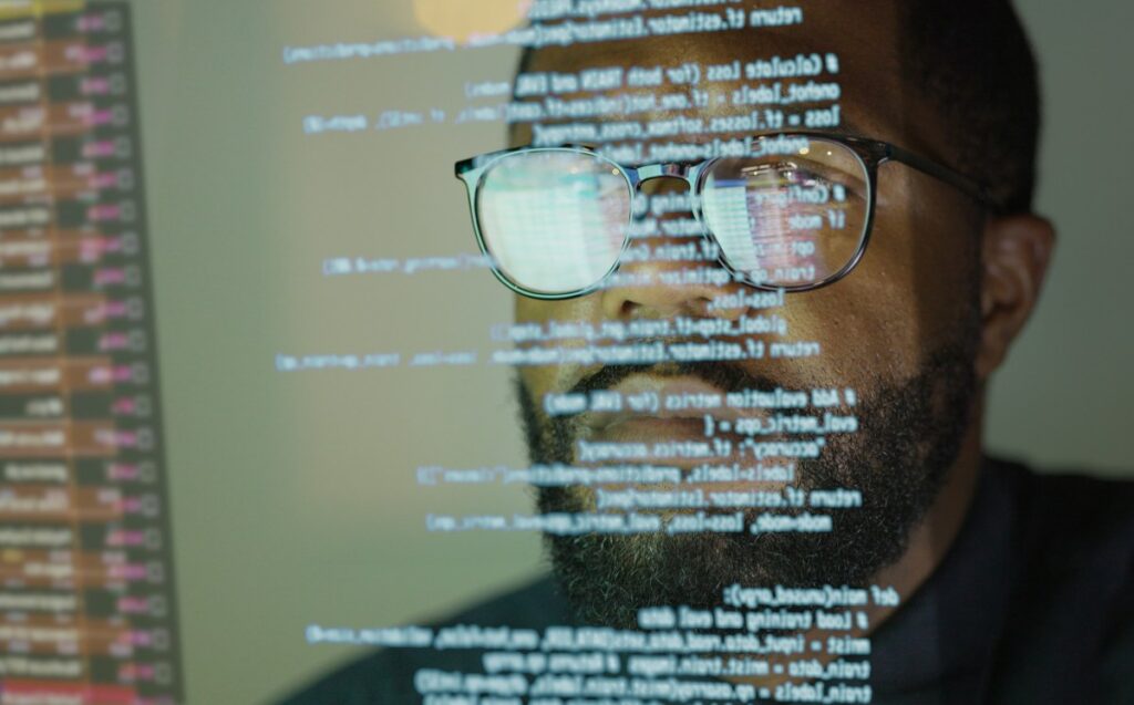 Man studying a see-through display depicting Python computer coding.