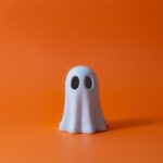 Cute Halloween Ghost over orange background.