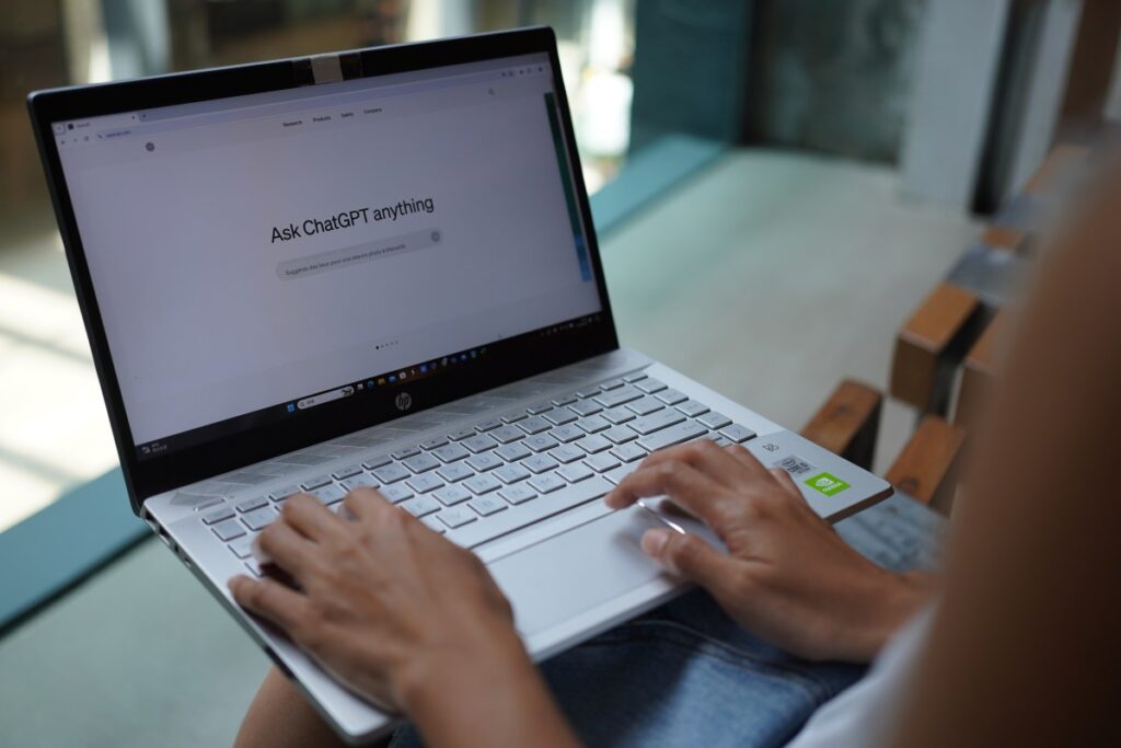 In this photo illustration, a woman browses OpenAI's website on her laptop