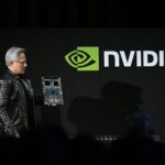 Jensen Huang, co-founder and chief executive officer of Nvidia, holds up the company's AI accelerator chips for data centers