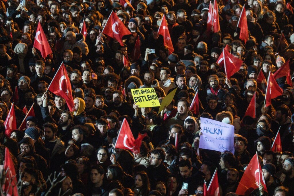 People wave flags and chant slogans during a protest in front of the municipality headquarters in support of arrested Istanbul Mayor Ekrem Imamoglu