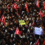 People wave flags and chant slogans during a protest in front of the municipality headquarters in support of arrested Istanbul Mayor Ekrem Imamoglu