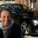 Errol Musk, father of Elon Musk, pictured in front of a Tesla