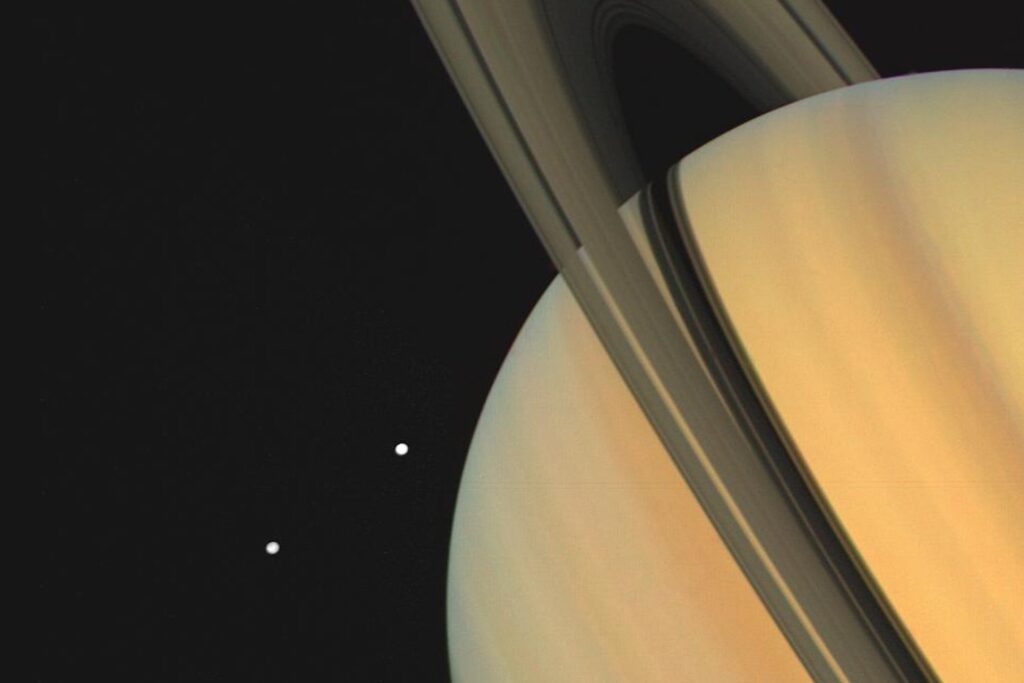 Saturn and two of its moons, Tethys (above) and Dione, as photographed by Voyager 1 on November 3, 1980.