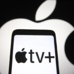 In this photo illustration an Apple TV+ logo is seen on a smartphone screen with an Apple logo in the background.