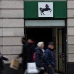 People walk past a branch of Lloyds bank in London