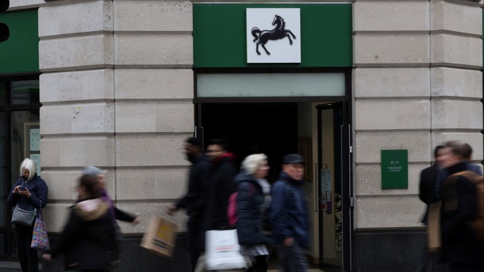 People walk past a branch of Lloyds bank in London