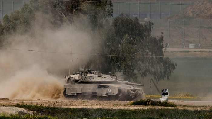 An Israeli tank manoeuvres on the Israeli side of the border between Israel and Gaza