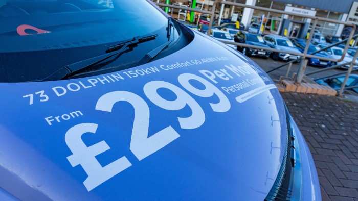 A blue car sitting on a showroom forecourt