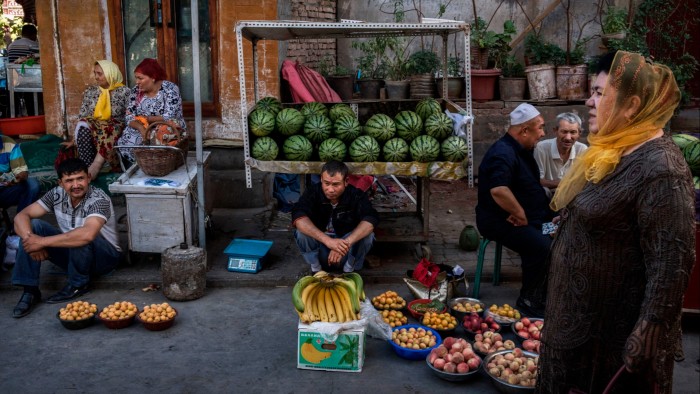 Uyghurs sell fruits at a market in the old town of Kashgar, in the far western Xinjiang region, China, in 2017