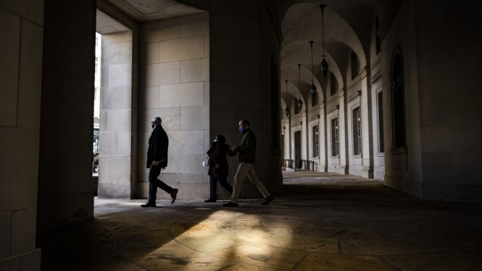 Pedestrians walk past the IRS headquarters in Washington DC